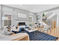 Bright living room featuring a modern fireplace and an open staircase design at 82 Oneida St, Denver, CO 80230