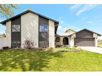 Charming two-story home featuring a well-manicured lawn and inviting front entrance, perfect for a Gathering at 2055 Quail Dr, Lakewood, CO 80215