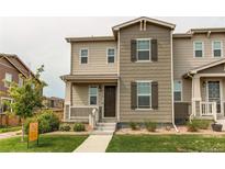 Inviting townhome with landscaped front yard, covered porch, and neutral tones at 21302 E Radcliff Pl, Aurora, CO 80015