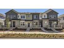 Beautiful townhome exterior featuring stone accents, varied siding, and a well-maintained front yard at 728 N Bently St, Watkins, CO 80137