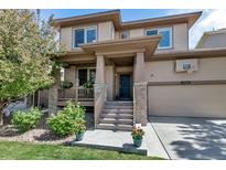 Inviting two-story home featuring a covered porch, basketball hoop, and well-maintained landscaping at 21658 E Tallkid Ave, Parker, CO 80138