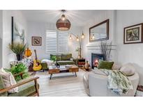 Cozy living room featuring a fireplace, a guitar, modern decor and ample natural light from the large window at 21658 E Tallkid Ave, Parker, CO 80138