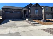 Charming home featuring stone accents, a two-car garage, and newly landscaped front yard with a concrete driveway at 21966 E 39Th Pl, Aurora, CO 80019