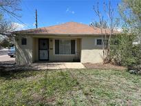 Charming single-story home featuring a quaint front yard with a concrete porch and secure front door at 1303 Havana St, Aurora, CO 80010