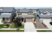 Beautiful two-story home with a large driveway, well-manicured lawn, and appealing landscaping at 17955 E 107Th Pl, Commerce City, CO 80022