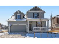 Charming two-story home features a covered front porch, attached garage, and landscaped front yard at 16572 E 109Th Ave, Commerce City, CO 80022