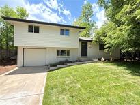 Charming two-story home featuring a well-manicured lawn and attached garage at 8426 W Woodard Dr, Lakewood, CO 80227
