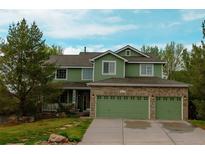 Inviting two-story home featuring a three-car garage and nicely landscaped front yard at 919 Taylor Ln, Erie, CO 80516