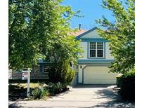 Two-story home with light-blue trim, a brick accent, and a two-car garage at 19954 E Dartmouth Ave, Aurora, CO 80013