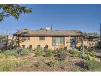 Charming single-story brick home with a well-maintained front yard and inviting curb appeal with seating area at 3224 Troy St, Aurora, CO 80011