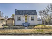 Exterior shot of a bright home with a well-manicured lawn and a detached garage providing ample parking at 4354 Chase St, Denver, CO 80212