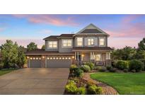 Charming two-story home featuring a large three-car garage and a welcoming front porch and professionally landscaped front yard at 2384 Crestridge Dr, Castle Rock, CO 80104