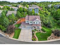 Stunning two-story home featuring a three-car garage, charming front porch, and beautifully landscaped front yard at 2384 Crestridge Dr, Castle Rock, CO 80104
