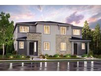 Two-story home with stone and gray siding, a well-manicured lawn, and a welcoming entrance at 14149 Deertrack Ln, Parker, CO 80134