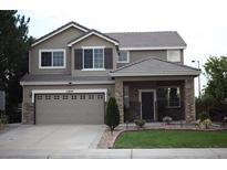 Charming two-story home with stone accents, well-maintained lawn, and a two car garage at 11800 Granby St, Commerce City, CO 80603