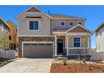 Charming two-story home featuring stone accents, a covered porch, and an attached two-car garage at 459 S Salida St, Aurora, CO 80017