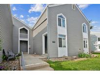 Attractive gray condo with white trim, a walkway, and a manicured lawn, located in a desirable community at 3331 S Monaco Pkwy # D, Denver, CO 80222