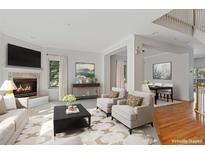 Elegant living room with a cozy fireplace and an open concept dining area for entertaining at 2660 S University Blvd # I, Denver, CO 80210