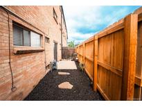 Private fenced yard with mulch, stone pavers, and a small patio area offering a serene outdoor space next to a brick building at 558 N Washington St # 103, Denver, CO 80203