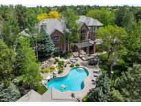 Stunning home aerial view featuring a pristine pool and lush landscaping nestled among mature trees at 5851 S Colorado Blvd, Greenwood Village, CO 80121