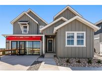 Beautiful home featuring gray siding, white trim, and a stylish red awning over the windows at 3456 Recess Ln, Castle Rock, CO 80108