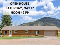 Charming ranch-style home with an attached garage, lovely landscaping, and mountain views at 26063 Morris Ave, Conifer, CO 80433