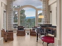 Bright living room with piano, comfortable seating, and scenic mountain view at 814 Neville Ln, Golden, CO 80401