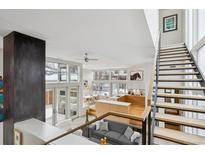 Bright and airy living room features an open floor plan with a modern staircase and large windows at 35 S Forest St, Denver, CO 80246