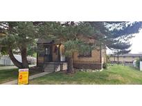 Charming brick home with a well-maintained lawn and mature trees, offering a cozy and inviting curb appeal at 9120 Elm Ct, Denver, CO 80260