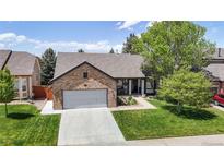 Charming single-story brick home with a well-manicured lawn and an attached two-car garage at 20855 Omaha Ave, Parker, CO 80138