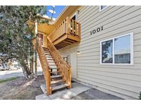 Tan two-story exterior with balcony and a wooden staircase leading to the front door at 1001 W 112Th Ave # D, Westminster, CO 80234