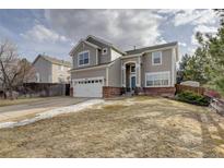 Charming two-story home with a manicured front yard and attached two-car garage and a brick foundation at 4053 S Riviera St, Aurora, CO 80018