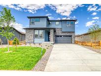 Beautiful two-story home featuring stone accents, a well-manicured lawn, and a spacious driveway at 23909 E 41St Ave, Aurora, CO 80019