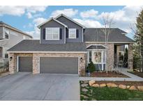 Charming two-story home boasts a three-car garage and manicured lawn with beautiful stone accents at 447 Winterthur Way, Highlands Ranch, CO 80129