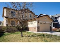 Charming two-story tan home with a welcoming front porch and attached two car garage at 6370 Twilight Ave, Firestone, CO 80504