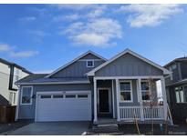 Gray exterior of charming craftsman style home with white trim and a two-car garage at 498 Grey Rock St, Brighton, CO 80601