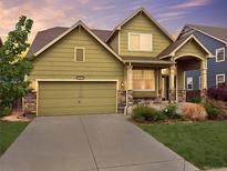 Charming two-story home featuring a well-maintained lawn, stone accents, and an attached two-car garage at 11649 E 111Th Ave, Commerce City, CO 80640