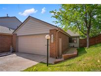 Charming townhome featuring a two-car garage with brick accents and well-maintained landscaping at 12668 W 1St Pl # 81, Denver, CO 80228