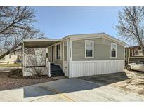 Charming manufactured home featuring a covered porch and driveway with mature trees, perfect for easy access at 2885 E Midway Blvd # 1542, Denver, CO 80234