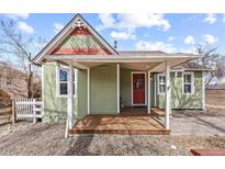 Charming home with a covered porch, red door, and quaint architectural details at 9551 W 38Th Ave, Wheat Ridge, CO 80033