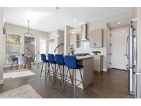 Modern kitchen featuring a large island with seating and stylish pendant lighting at 5026 S Platte River Pkwy, Littleton, CO 80123
