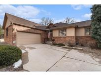 Charming single-Gathering home featuring a brick exterior, two-car garage, and well-manicured front yard at 7288 S Sundown Cir, Littleton, CO 80120