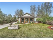Charming single story home featuring a covered front porch, mature landscaping, and a well manicured lawn at 4965 Dover St, Arvada, CO 80002