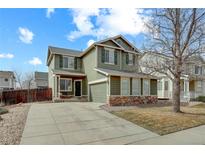 Charming two-story home with green siding, stone accents, and a well-manicured front yard at 10505 Wheeling St, Commerce City, CO 80022