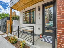 Inviting front porch with modern railings, wooden bench, and flowerbed leading to the front door at 4025 Jason St # 101, Denver, CO 80211