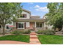 Charming two-story home featuring a quaint front porch, well-maintained lawn and beautiful landscaping at 5107 Pasadena Way, Broomfield, CO 80023