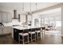 Open kitchen with a large island, modern appliances, and seating for dining at 8110 S Kellerman Cir, Aurora, CO 80016