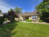 Charming single-story home with a well-manicured lawn and mature landscaping at 7290 S Cook Cir, Centennial, CO 80122