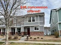 Attractive townhome boasts a brick facade, gray siding, and a well-maintained front yard at 5776 Biscay St, Denver, CO 80249