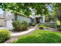 Charming home featuring a well-manicured lawn, stone accents and mature trees, creating curb appeal at 1361 Castlepoint Cir, Castle Pines, CO 80108
